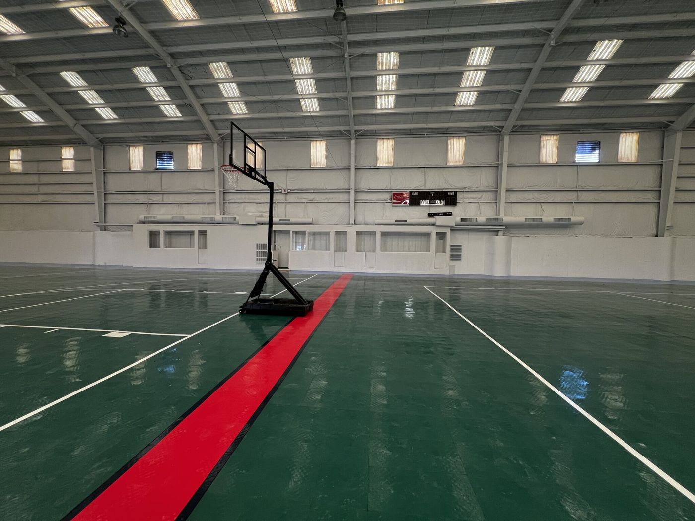 Basketball hoop on the green court with red center stripe